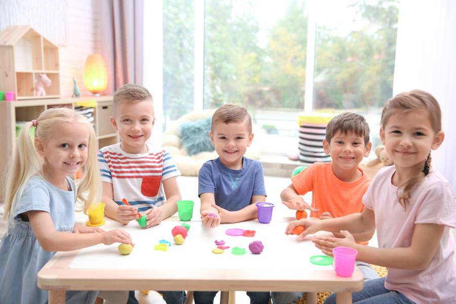 Kids learn while playing at an activity table in daycare